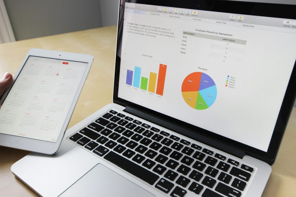 pexels-photo-265087-265087 Laptop displaying charts and graphs with tablet calendar for data analysis and planning.
